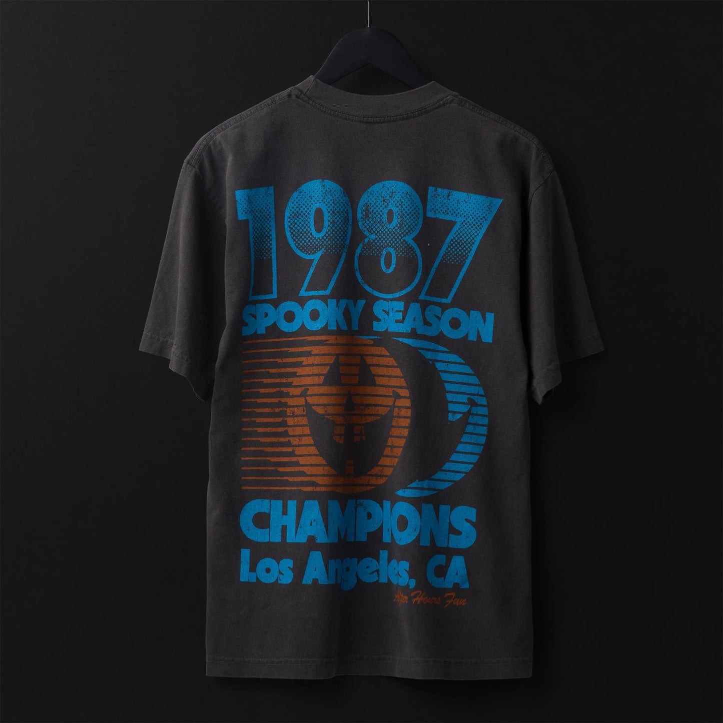 Black t-shirt with blue and orange text and graphics on a dark background
