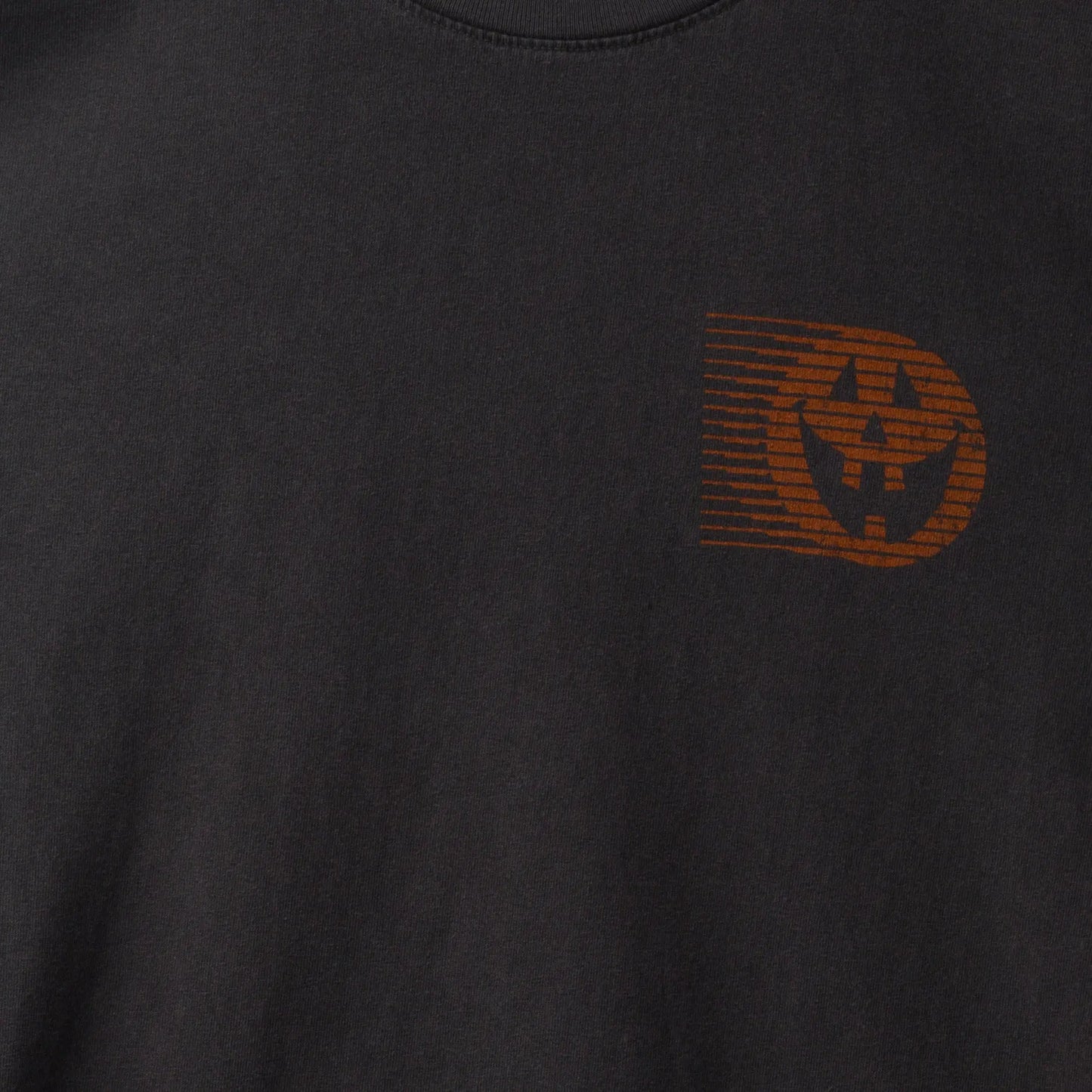 Black t-shirt with a brown logo on a dark background